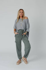 Model styled in Easy Mornings Cinched Pants by Three Bird Nest in light olive, paired with a loose gray top and platform sandals