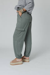 Side angle of the Easy Mornings Cinched Pants by Three Bird Nest in light olive, showcasing relaxed fit and cargo pockets.