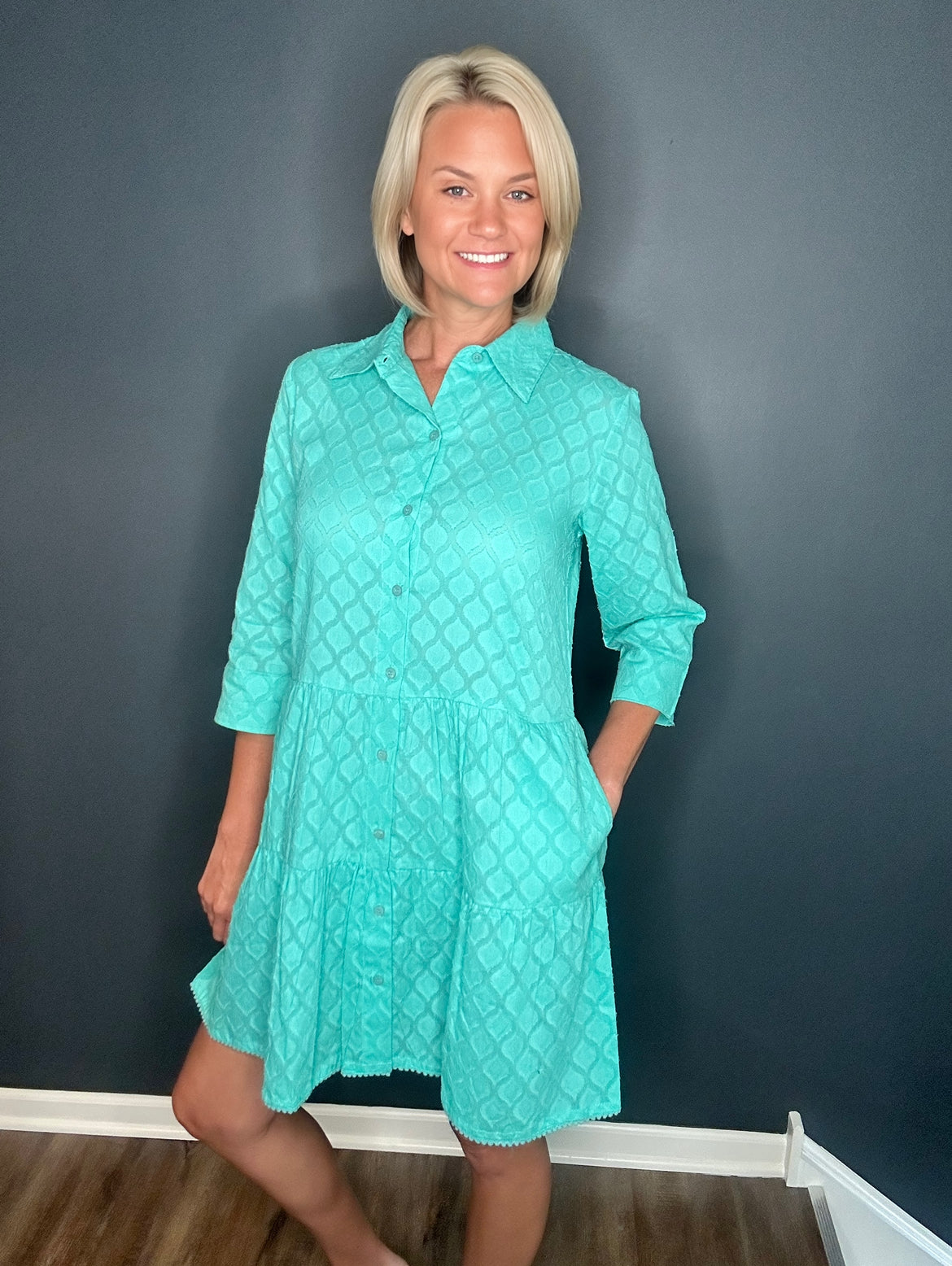 Model smiling in the Moda Posa Alcee Turquoise Shirt Dress styled casually, highlighting its button-down design and lightweight cotton fabric.