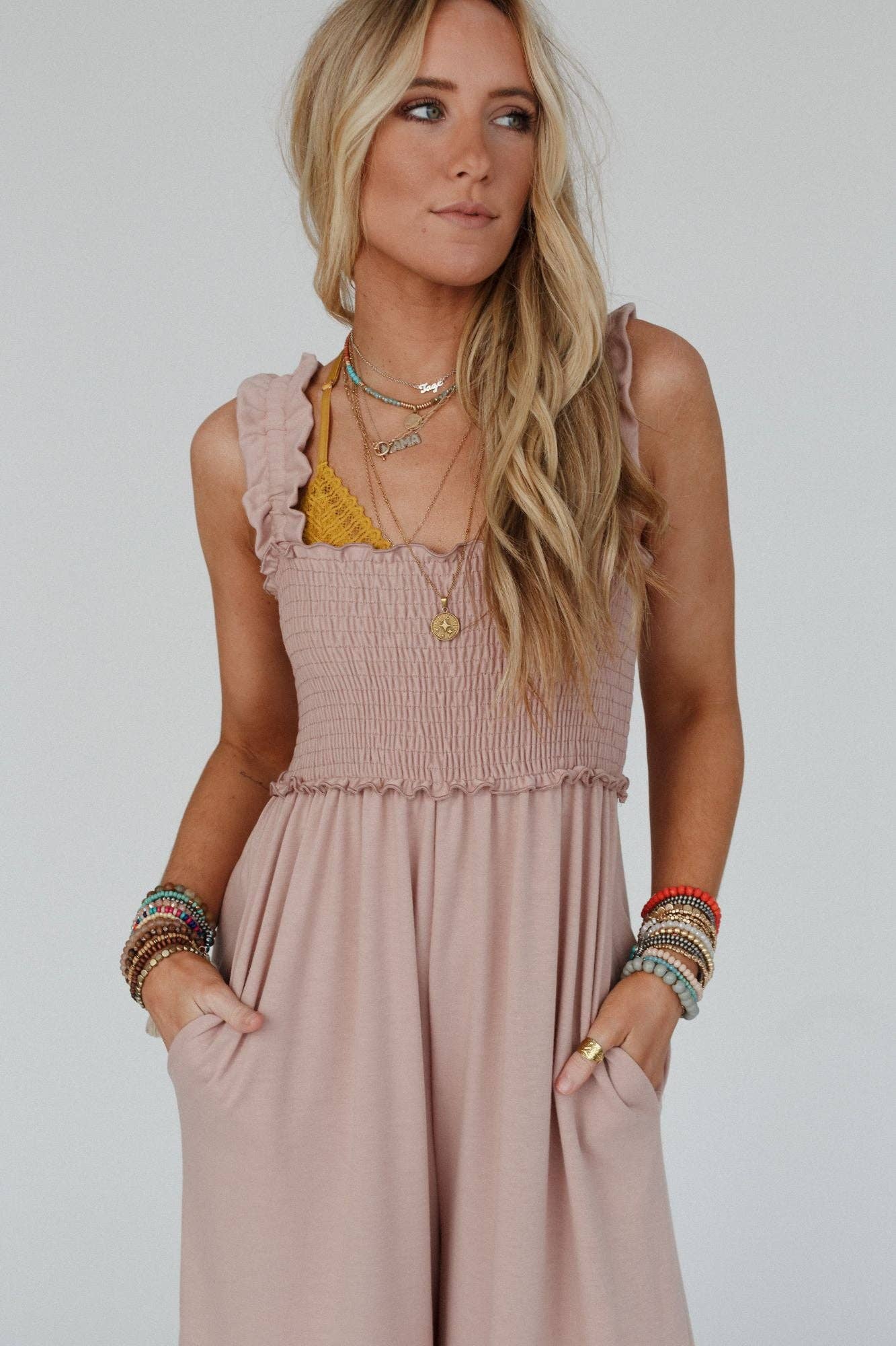 Close-up of the smocked top of the Three Bird Nest Jumpsuit in dusty rose, showcasing textured fabric and ruffle trim detail, perfect for a relaxed boho-chic look.