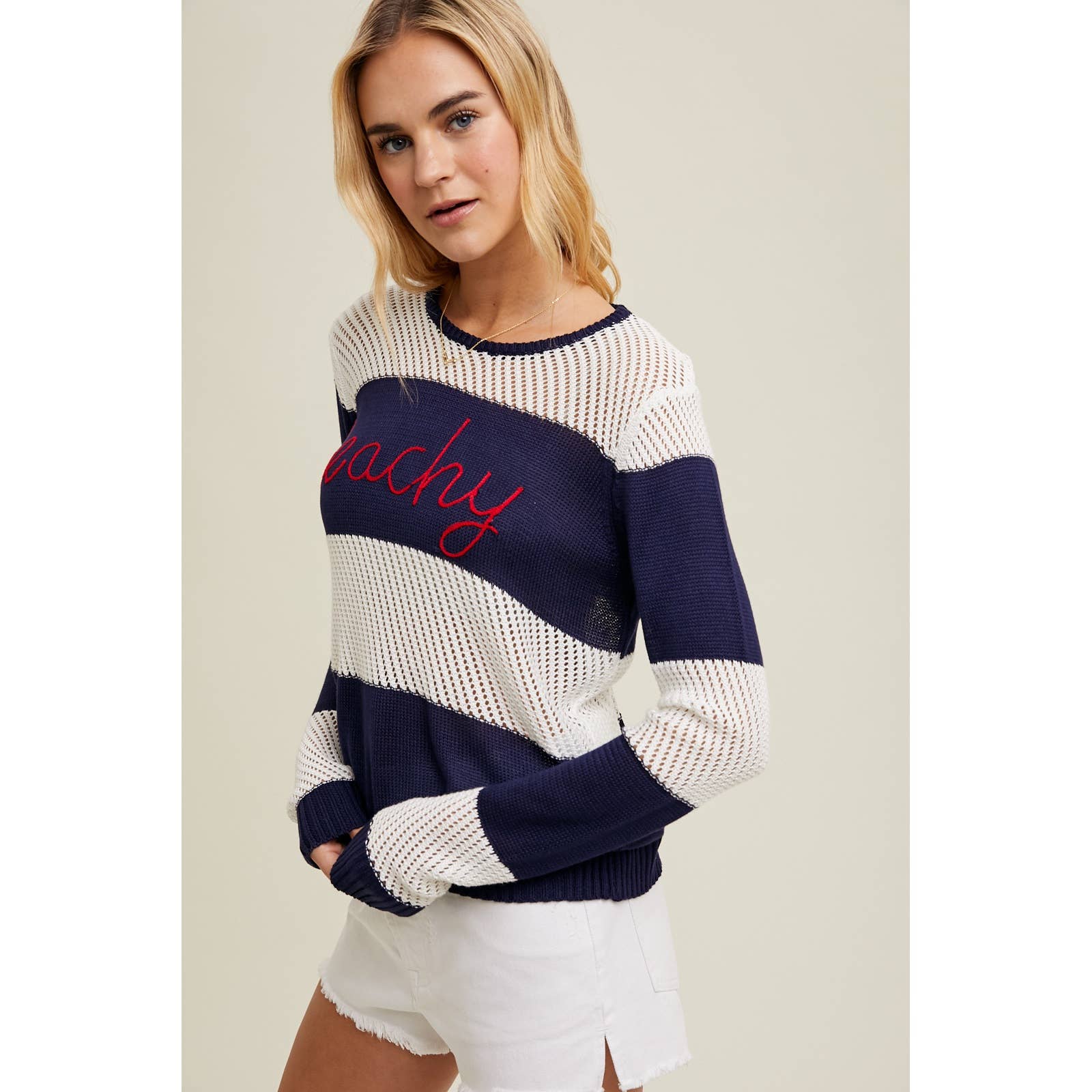 Side view of the Wishlist Beachy Embroidered Striped Sweater Top styled with white shorts, featuring semi-sheer lightweight fabric and relaxed stripes.