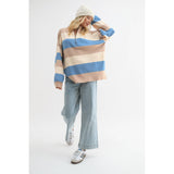 Model in motion wearing the Wishlist Striped Half-Zip Sweater Pullover, styled with denim flares and featuring beige, blue, and cream stripes.