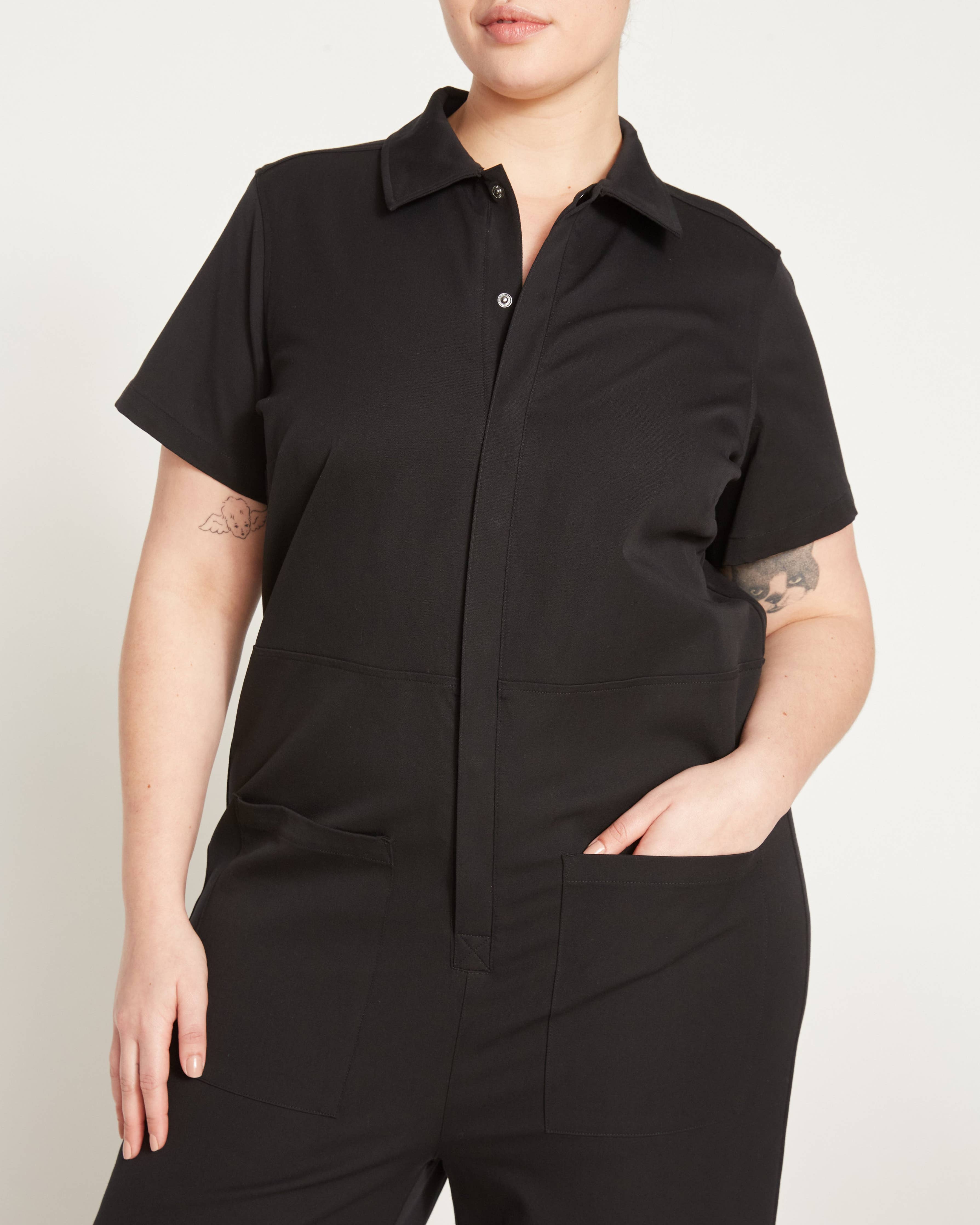 Close-up of the Kate Stretch Jumpsuit in black, highlighting its functional patch pockets and sleek tailoring.