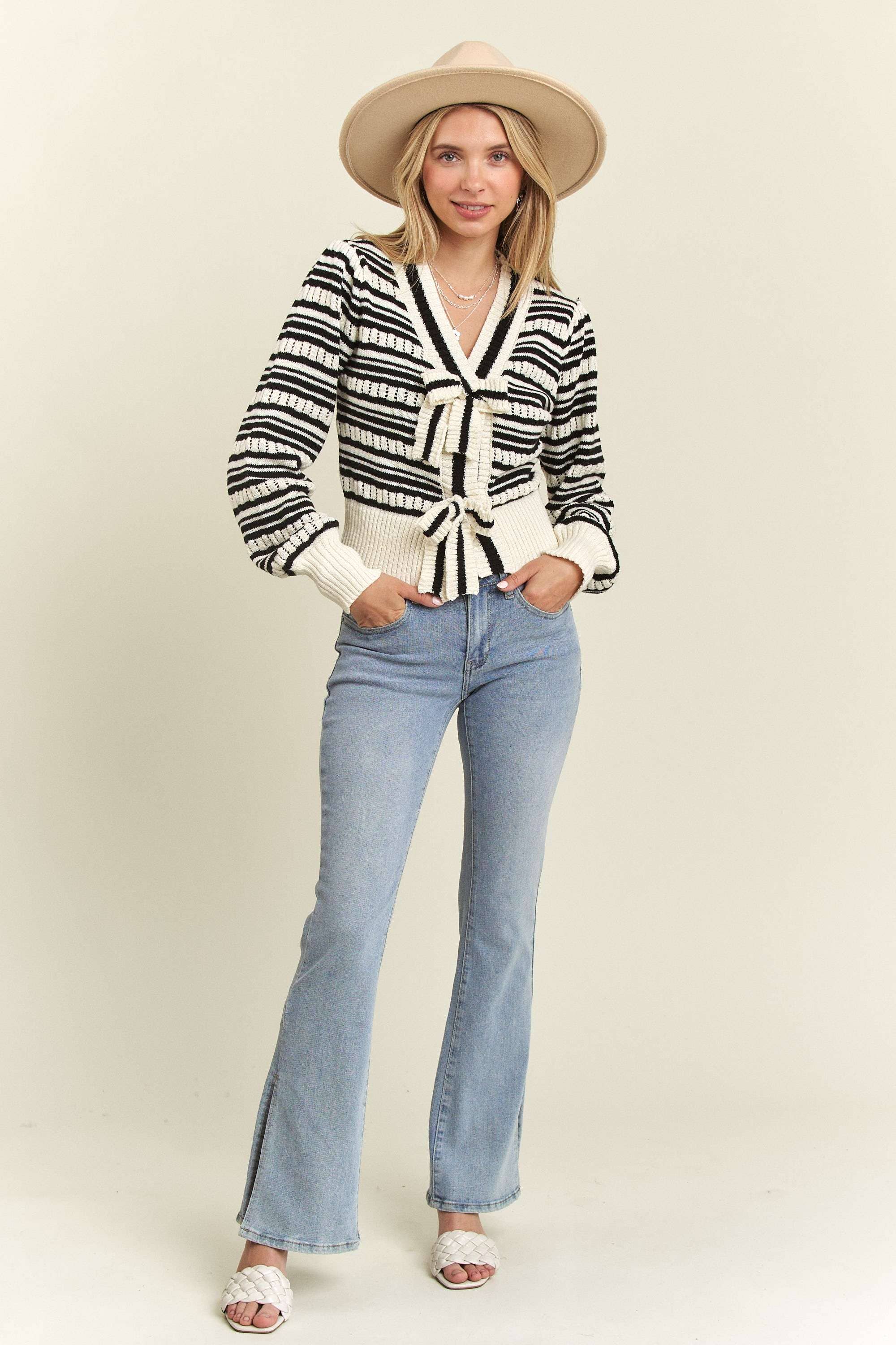 Front view of the Madelyn Bow Tie Sweater styled with light-wash jeans and a wide-brimmed hat for a laid-back, boho look.