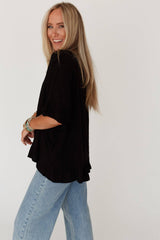 Side view of the THREE BIRD Nest Let Me Be Ruffled Top in black, featuring fluttery sleeves and a relaxed, flowy fit perfect for beachy boho vibes.