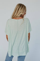 Back view of the THREE BIRD Nest Nestled top in soft sage, showcasing its flowy fit and raw seam detailing for a laid-back boho vibe.