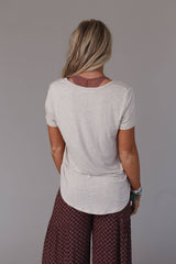 Back view of the Three Bird Nest Scoop Neck Bralette Tee in heather oatmeal, featuring a relaxed fit and soft fabric.