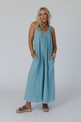 Front view of the Seraphina Jumpsuit by Three Bird Nest in Sea Foam, showcasing a relaxed, boho-inspired fit with a wide leg silhouette. The model has her hands in the pockets and is styled with boho accessories. 