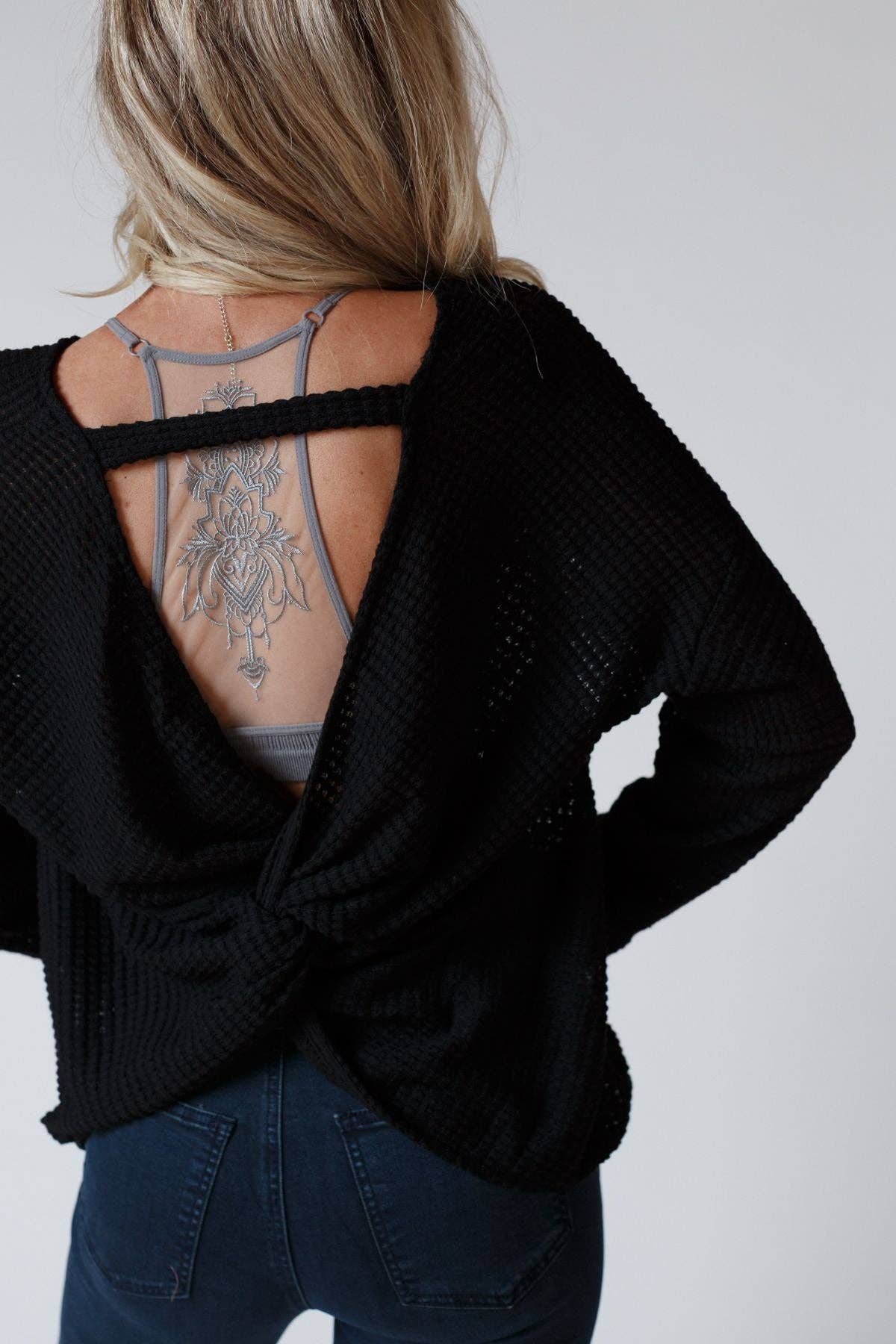 Back view of the Flattering Open Back Thermal Knit Top by Three Bird Nest featuring a twist detail and open-back design.