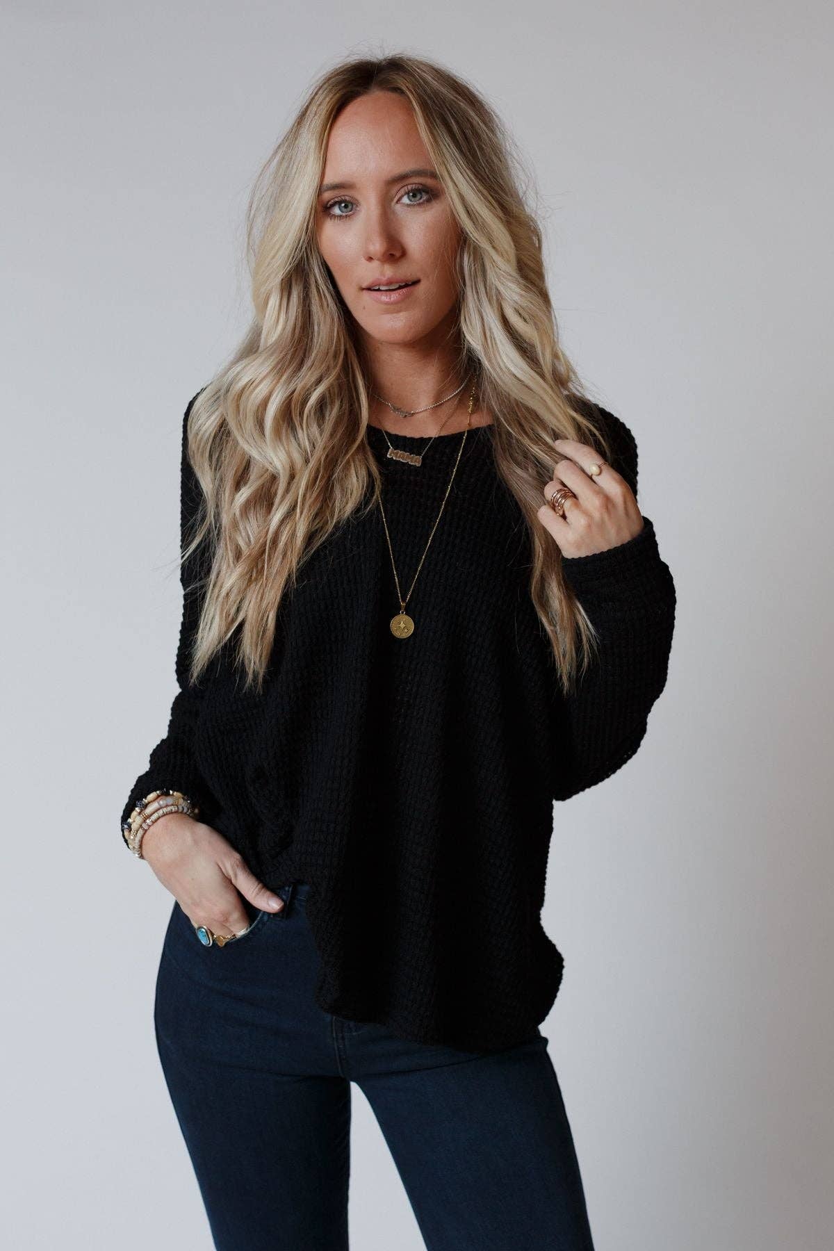 Model styling the Flattering Open Back Thermal Knit Top by Three Bird Nest with layered jewelry and denim for a boho-chic vibe.