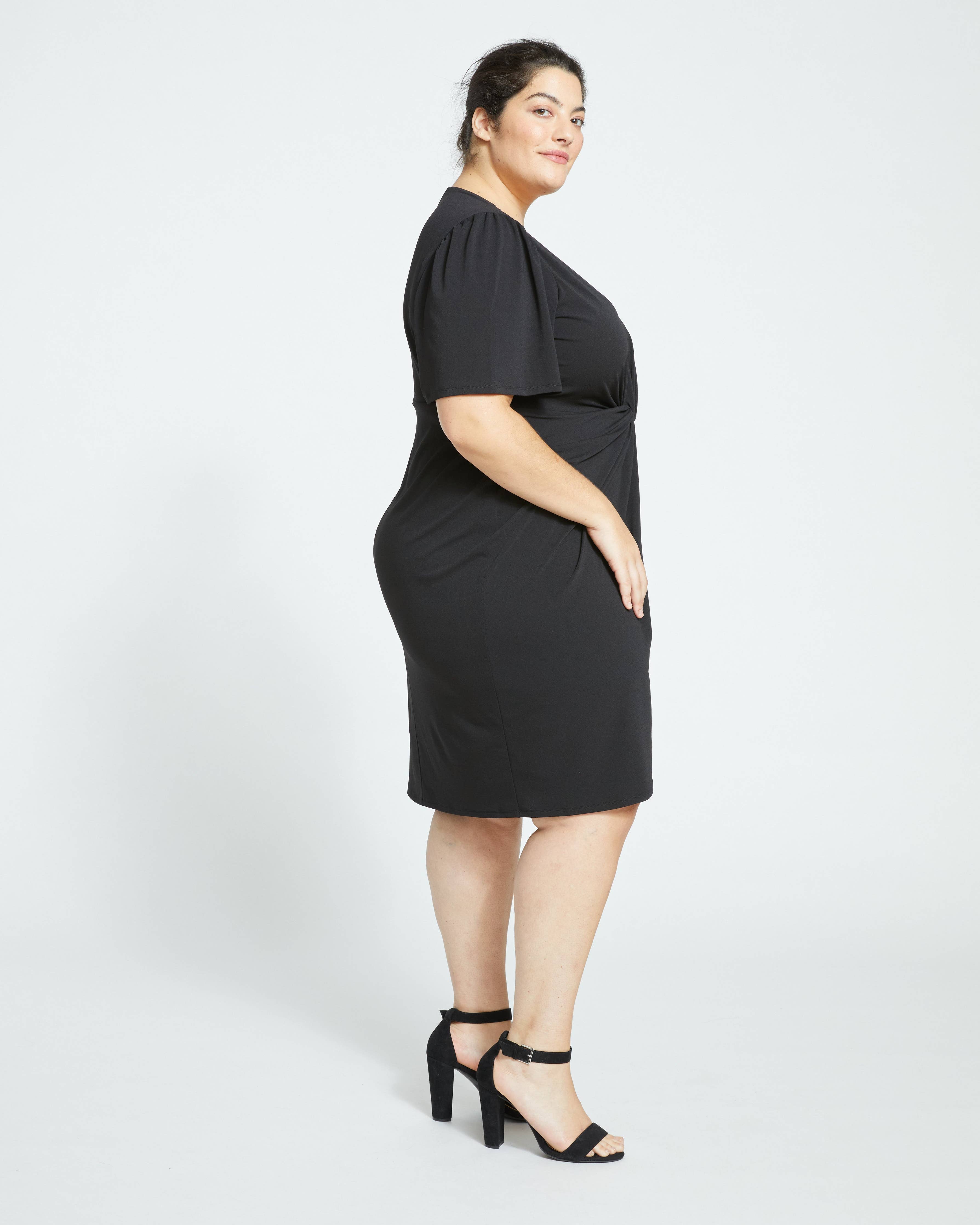 Side view of the model showing the Universal Standard Black Crepe Plus Size Dress. 