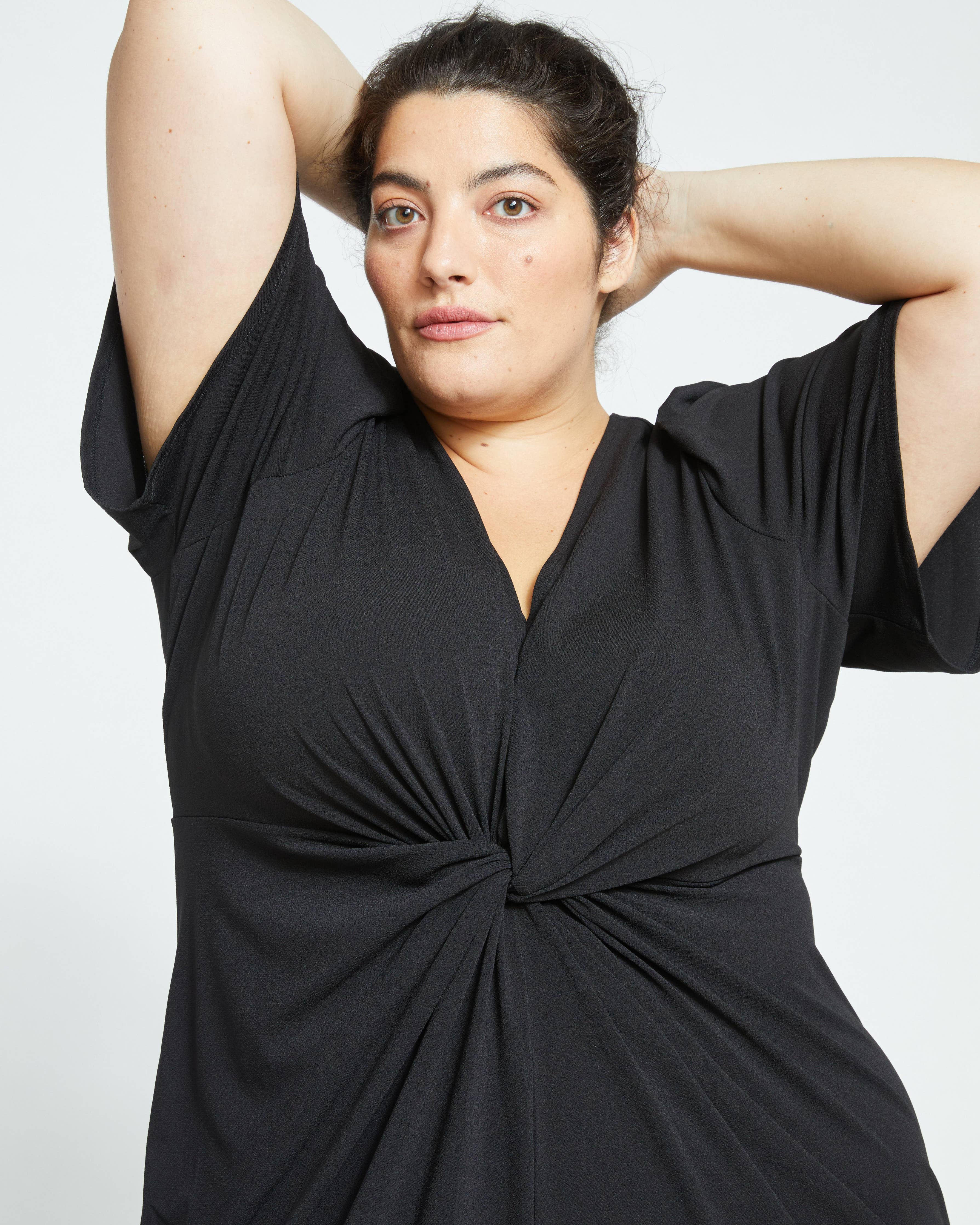 Up close front view of the Universal Standard Modiva Black Crepe Plus Size Dress showing the front twist details. 