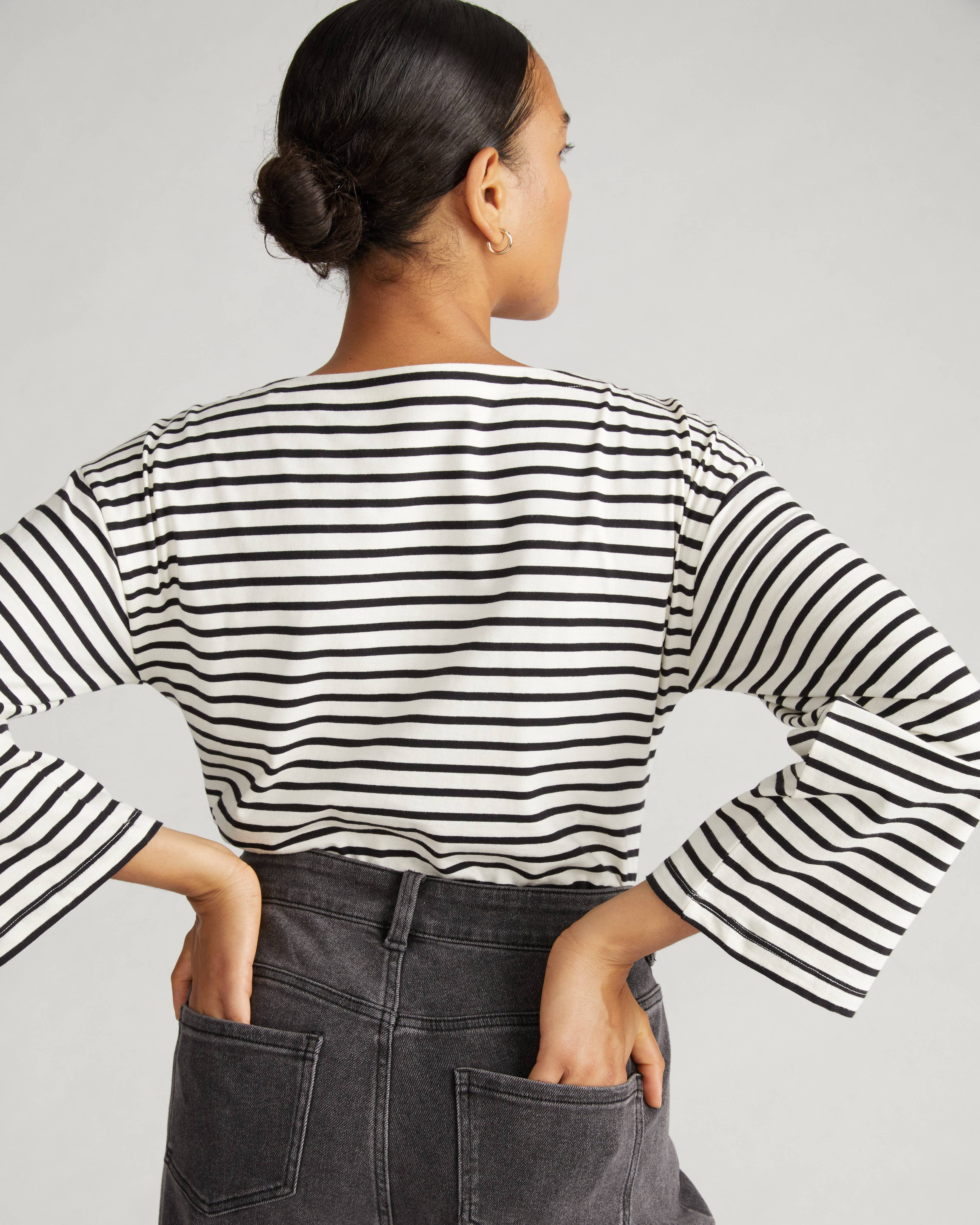 Back view of the Universal Standard Montauk Breton Stripe Bell Sleeve Top in ecru and black stripe, highlighting the classic stripe design and relaxed fit.