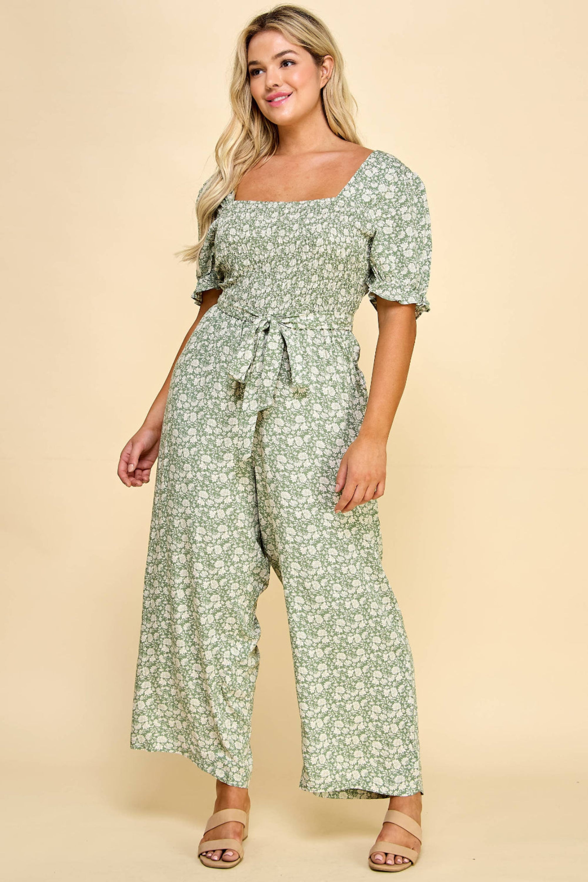 Side view of the Winslow Collection gaucho jumpsuit in plus size, highlighting the green floral print and stylish waist tie.
